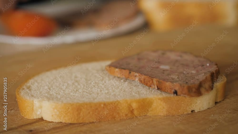 Detail of kitchen table with food and male hands making sausage sandwich, close up. Man cooking sandwich with sausage and tomato on a wooden table in the rustic kitchen Shooting closeup. Slow motion. Detail of kitchen table with food and male hands making sausage sandwich, close up. Man cooking sandwich with sausage and tomato on a wooden table in the rustic kitchen Shooting closeup. Slow motion.