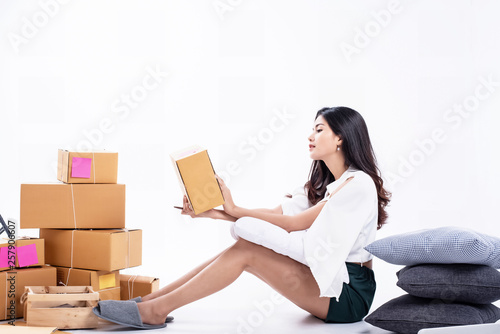 The beauty woman holding post box in hand prepare for packing and send to customer,working e-commerce at home