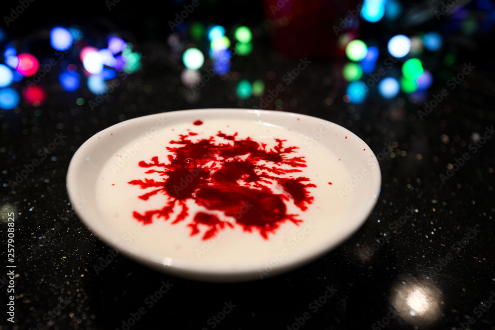 Woman is cooking in kitchen, baking a red velvet cake. Using red food