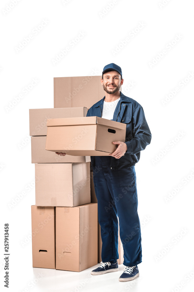handsome mover in uniform carrying cardboard box, smiling and looking at camera isolated on white handsome mover in uniform carrying cardboard box, smiling and looking at camera isolated on white