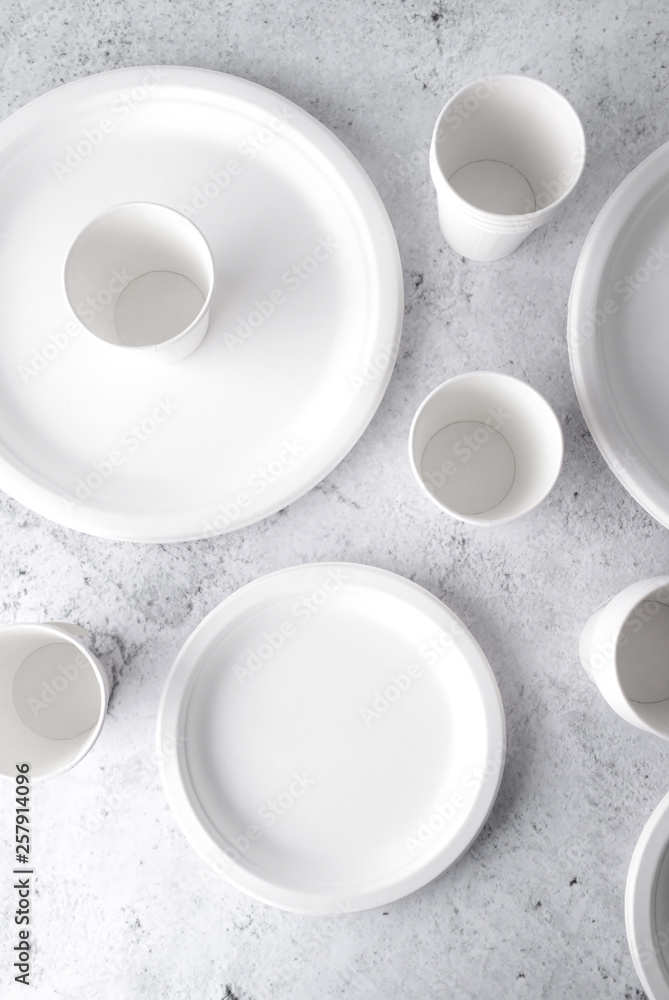 set of empty reusable disposable eco-friendly plates, cups, utensils on light white and grey concrete table top with copy space. Top view. set of empty reusable disposable eco-friendly plates, cups, utensils on light white and grey concrete table top with copy space. Top view.