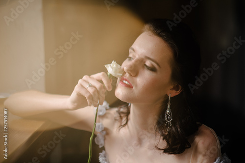 Woman in a dress holding a white rose