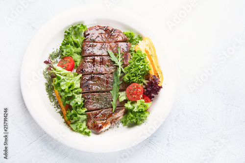 Grilled beef steak and fresh vegetables on plate