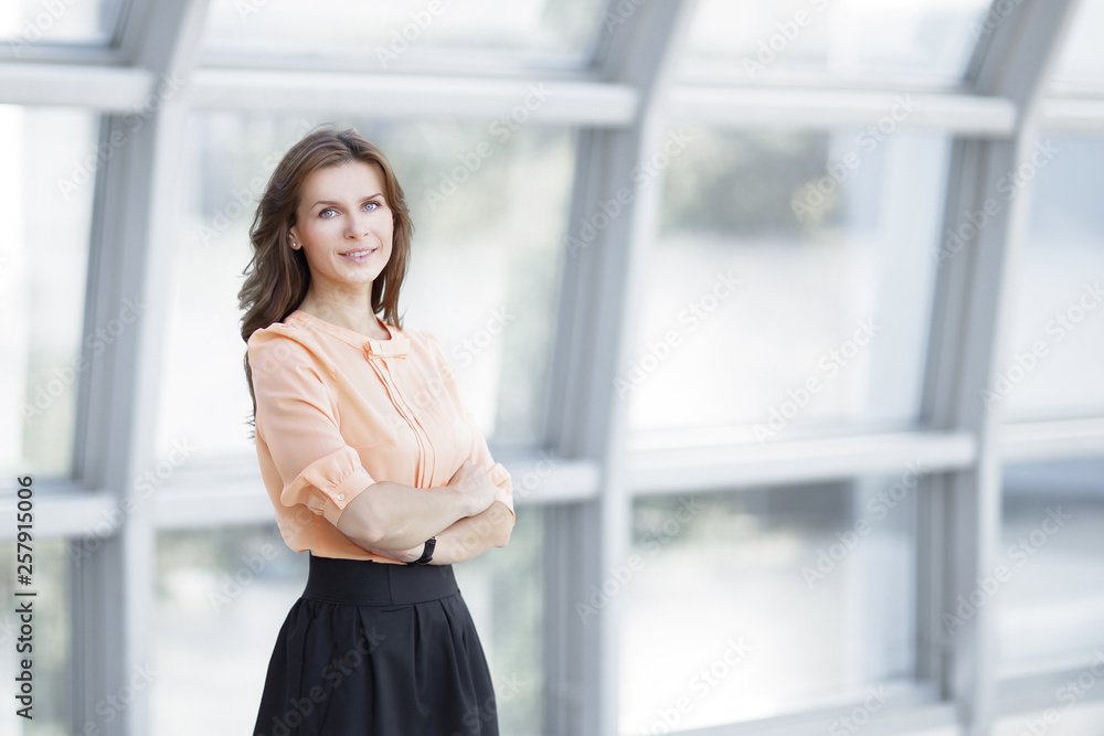 modern business woman standing near a large window in the office.