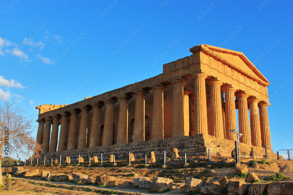 Temple of Concord in Valley of Temples in rays of spring sun in Agrigento on island of Sicily. Travel to Italy.