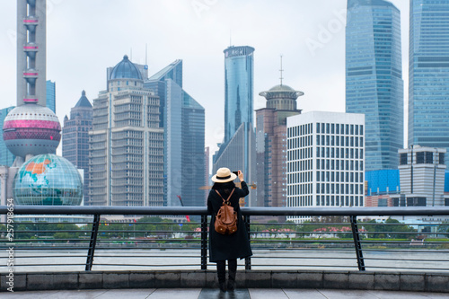 Photography A woman tourist is taking a photo by smart phone at Shanghai.