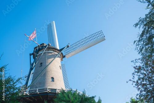 white mill with flag of historical city Alkmaar, The Netherlands, against blue sky