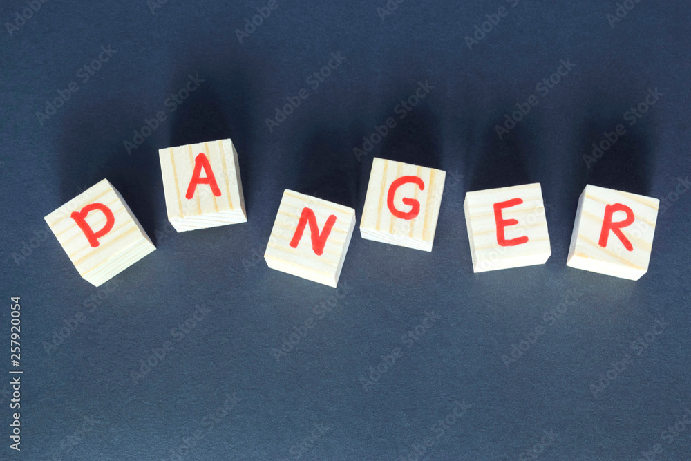 Word Danger written on wooden cubes on the dark background. Word Danger written on wooden cubes on the dark background.