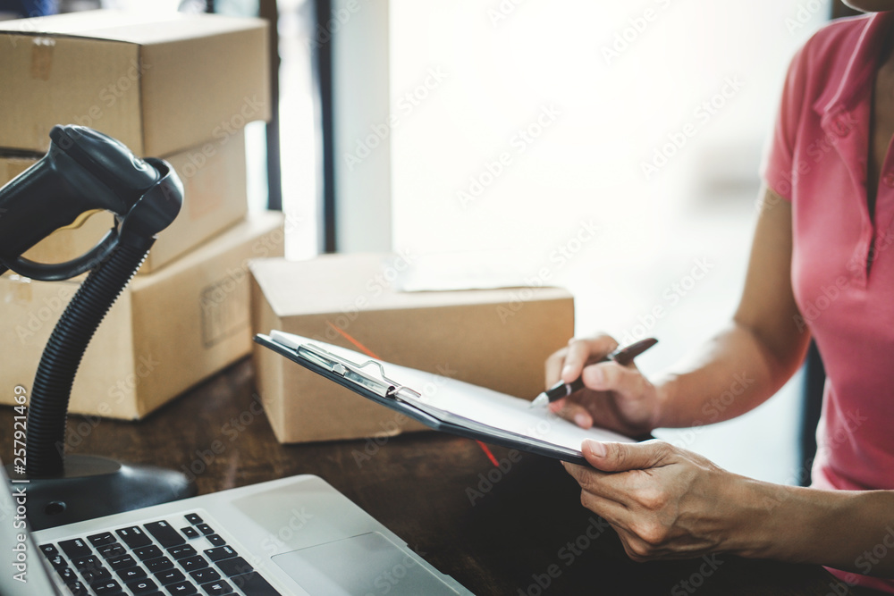 Fototapeta premium Home delivery service and working service mind, Woman working checking order to confirm before sending customer in post office