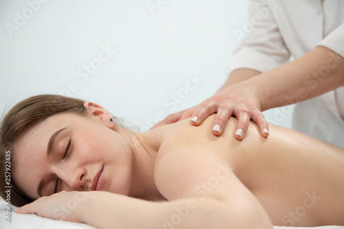 Relaxed woman receiving neck massage in wellness center