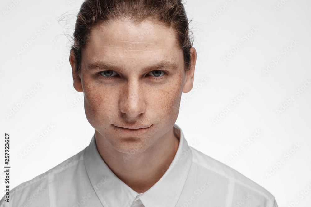 Portrait of a handsome long-haired man with drawn hair and freckles dressed in a white shirt Portrait of a handsome long-haired man with drawn hair and freckles dressed in a white shirt