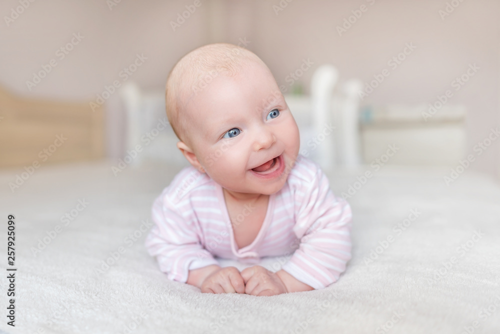 A small baby in a good mood. Baby girl lying on the bed. A small baby in a good mood. Baby girl lying on the bed.