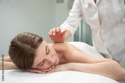 Beautiful young woman receiving massage in spa salon