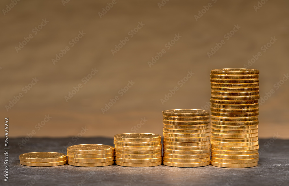 Concept illustration of growth of price of gold with stacks of gold eagle US Treasury golden coins Concept illustration of growth of price of gold with stacks of gold eagle US Treasury golden coins