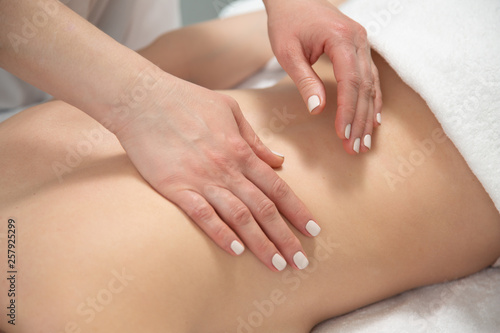 Fototapeta Naklejka Na Ścianę i Meble -  close-up masseur hands doing back massage in spa center. high key photo