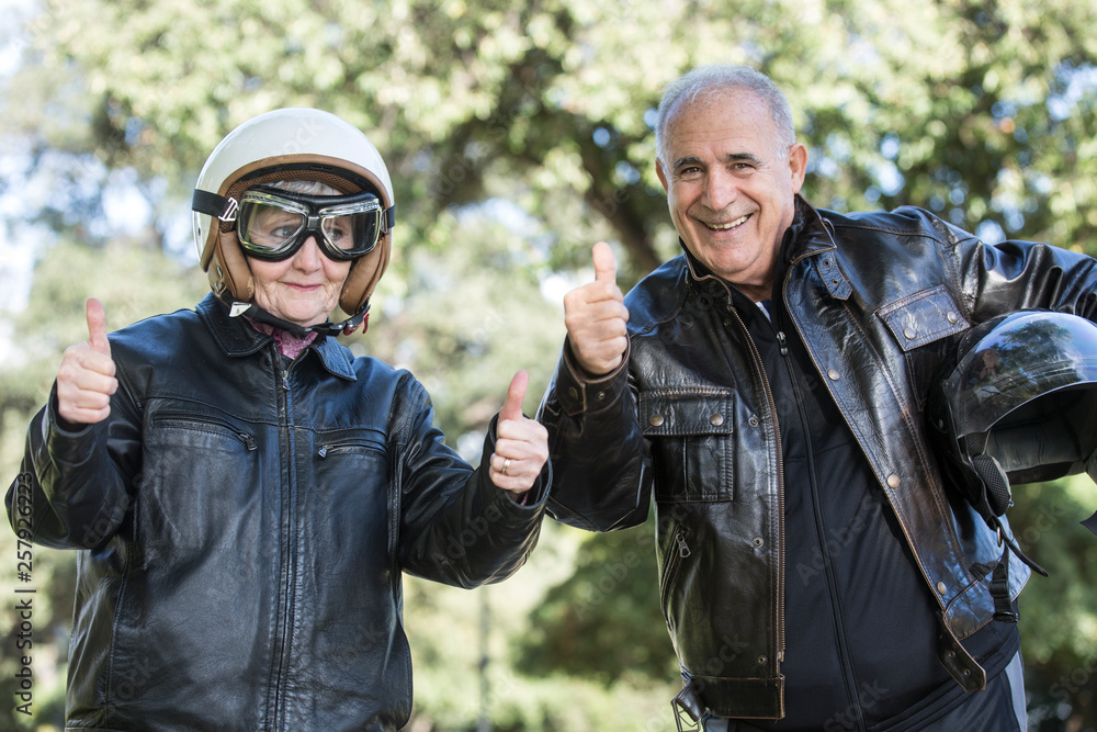 Coppia di anziani motociclisti  fa il segno di ok con il police riverso