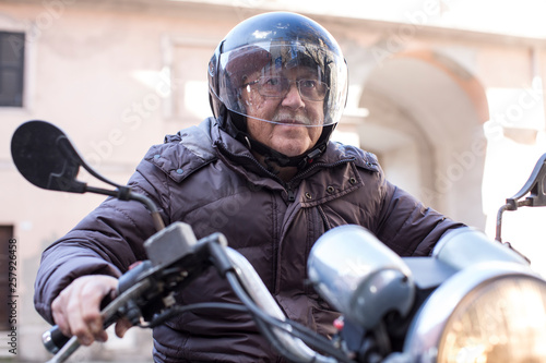Anziano signore con il casco guida la sua Motocicletta d'epoca