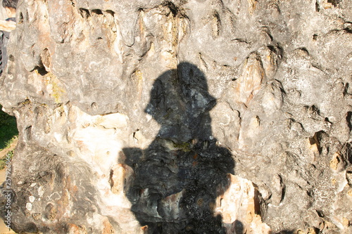 shadow of tourists on rough rocks