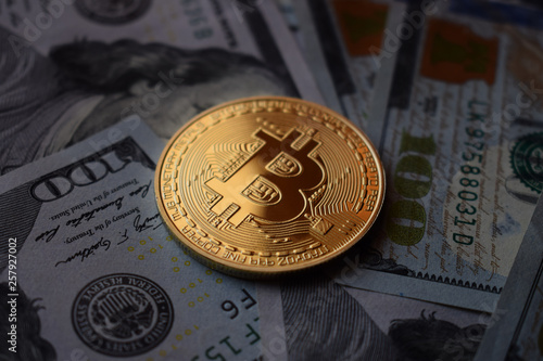 Golden coin Bitcoin on a US Dollars