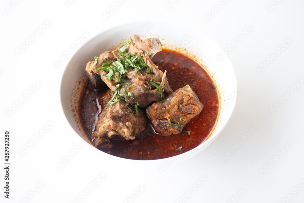 Pork bone in spicy soup served on white table in canteen Pork bone in spicy soup served on white table in canteen