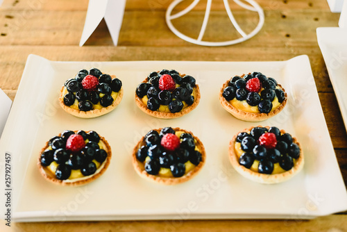 juicy red fruits prepared on puff pastry tarts and on puff pastry tartlets