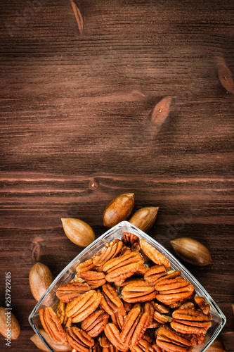 Pecan nuts in the shell with pecan kernel on wooden background