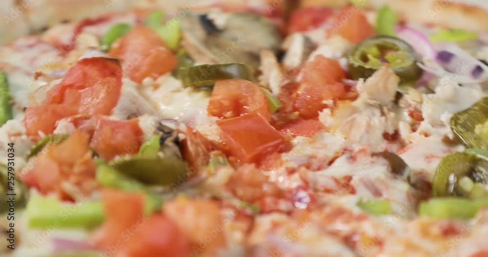 Close-up view of rotating tasty pizza with bacon and vegetables. Tasty italian food. Close-up view of rotating tasty pizza with bacon and vegetables. Tasty italian food.