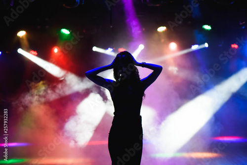 Silhouette of dancing girl against disco lights