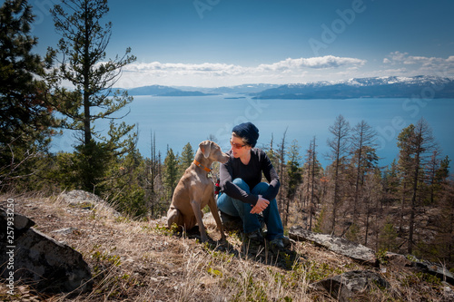 Woman with weimaraner dog sitting on rock  photo