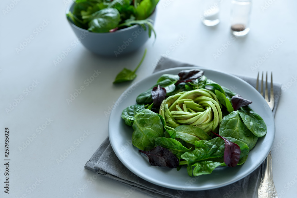 Salad mix with avocado, spinach and beet leaves on gray wooden background. Vegetarian food concept. Selective focus. Copy space Salad mix with avocado, spinach and beet leaves on gray wooden background. Vegetarian food concept. Selective focus. Copy space