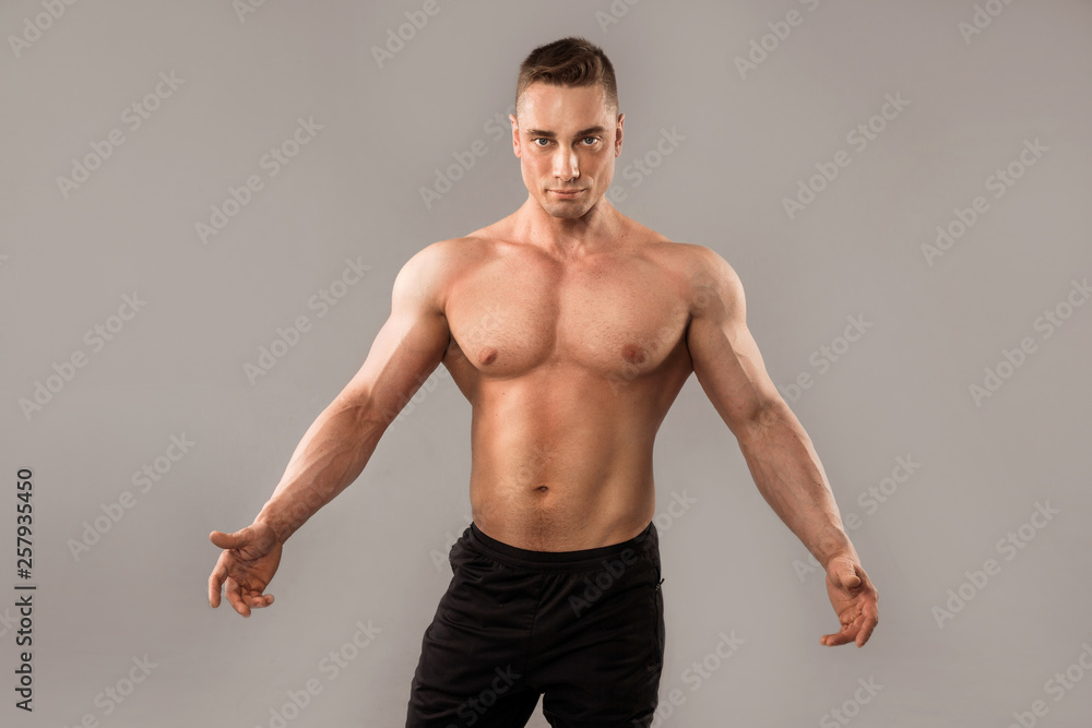 handsome man with muscles on gray background handsome man with muscles on gray background