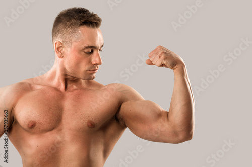 handsome man with muscles on a gray background with muscles