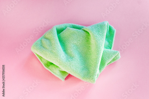 Microfiber green for cleaning on pink background. top view