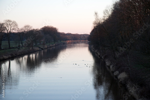 blick auf die ems und die bepflanzten ufer in fresenburg emsland deutschland fotografiert an einem lauen sommer abend bei sonnenuntergang photo