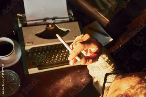 Young man writing on old typewriter.
