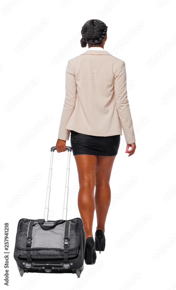 Back view of black African-American in formal attire walking with a suitcase. Back view of black African-American in formal attire walking with a suitcase.