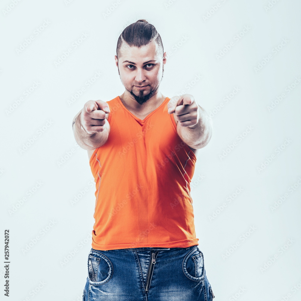 portrait of a sporty guy - bodybuilder in jeans and orange t-shi portrait of a sporty guy - bodybuilder in jeans and orange t-shi