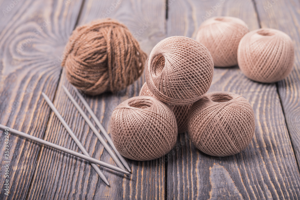 Balls of yarn and knitting needles for knitting on a wooden background. Balls of yarn and knitting needles for knitting on a wooden background.