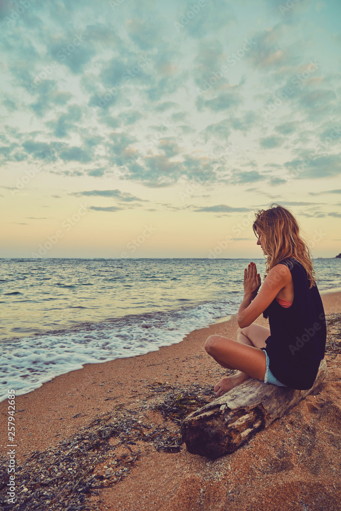 Young woman practicing yoga on the beach. Young woman practicing yoga on the beach.
