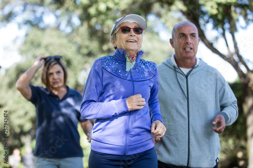 Anziani signori fanno attività di Jogging in mezzo ad un parco 