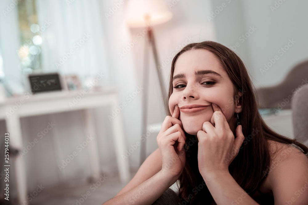Upset teenager girl trying to make a smile Upset teenager girl trying to make a smile