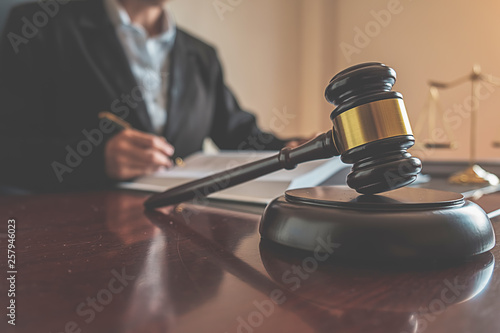 Pojęcie sprawiedliwości i prawa. Radca prawny przedstawia klientowi podpisaną umowę z młotkiem i prawem lub organizuje spotkanie prawne w kancelarii prawnej w tle