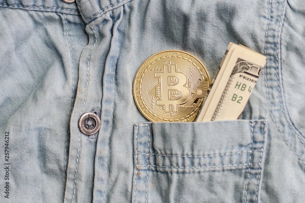 Bitcoin cryptocurrency in the pocket of white jeans and one hundred american dollars Bitcoin cryptocurrency in the pocket of white jeans and one hundred american dollars