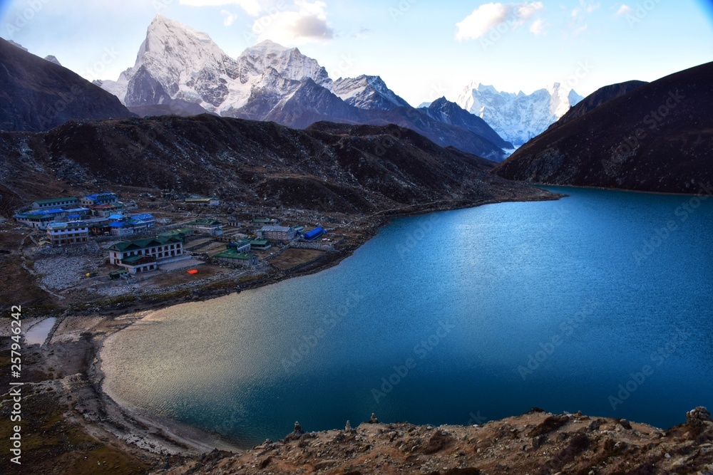 Blue lake with town lost between Himalayan mountains