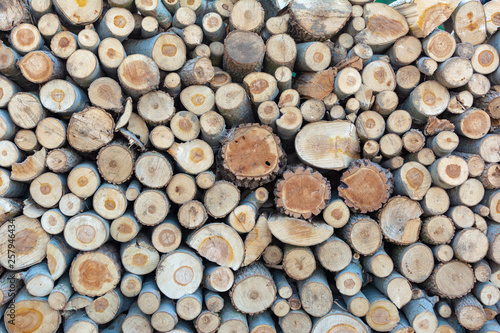 Firewood pile stacked chopped wood trunks  close-up wooden background