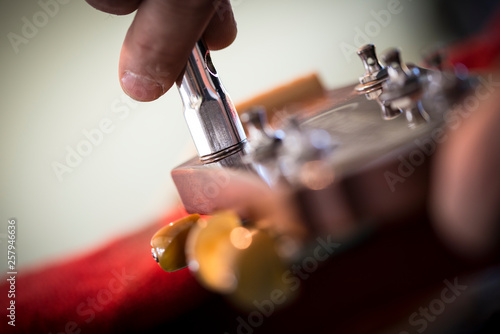 liutaio accorda chitarra con attrezzi