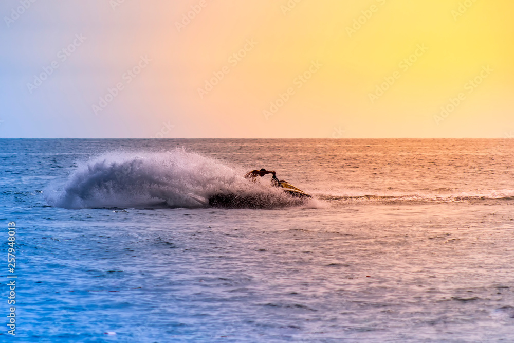 Fototapeta premium Man drive freestyle jet ski at summer sunset.