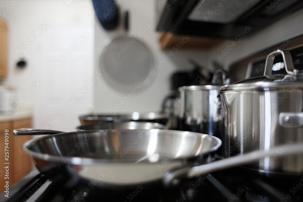 Modern gas stove with stainless steel cookware in a home kitchen. Modern gas stove with stainless steel cookware in a home kitchen.
