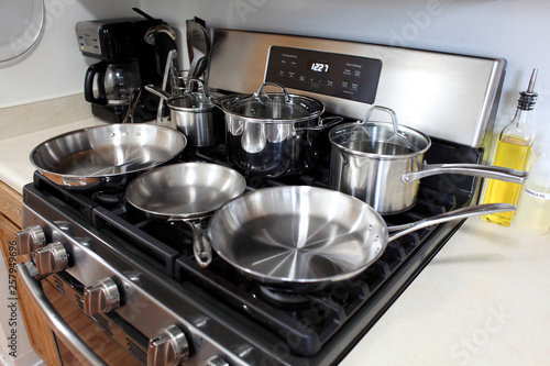 Modern gas stove with stainless steel cookware in a home kitchen.