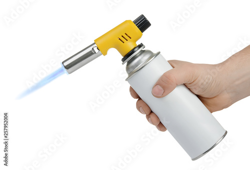 Hand holding gas can with manual torch burner (blowtorch) with blue flame isolated on white background. Serie of tools.
